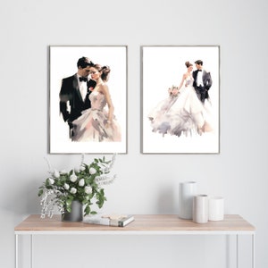 May include: Two framed watercolor prints of a bride and groom. The first shows the couple close together, the second shows them standing together. The bride wears a white dress, and the groom wears a black tuxedo.