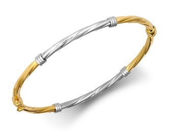 May include: A gold and silver twisted bangle bracelet. The bracelet is made of two different metals, one gold and one silver, that are twisted together to create a unique design.