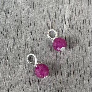 May include: A white ceramic mug with a black handle and the text "But First, Coffee" in a black, handwritten-style font. The mug is on a white surface.