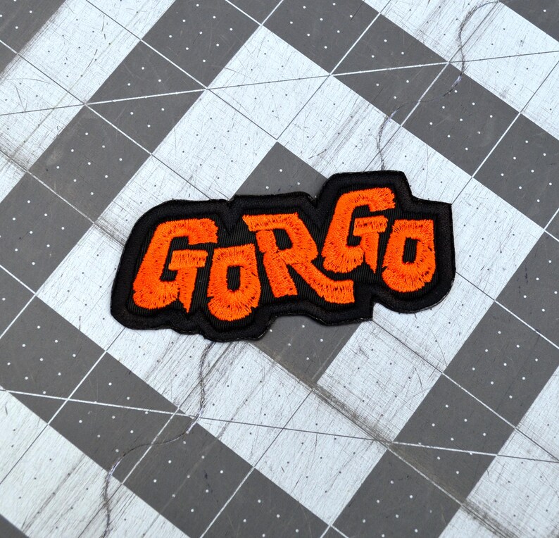 Orange and black embroidered logo patch for the classic Kaiju monster movie Gorgo.