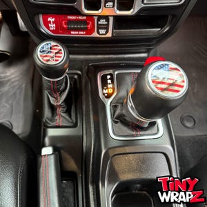 Pegatina de vinilo premium para pomo de palanca de cambios Jeep con diseño de "bandera estadounidense topográfica". Compatible con Wrangler JL y Gladiator de 2018 a 2026.