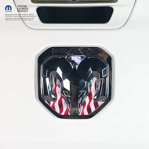 May include: A chrome RAM emblem with a red and white striped design, resembling the American flag. The emblem is set against a white background. The top of the image shows the text "OFFICIAL LICENSED PRODUCT".
