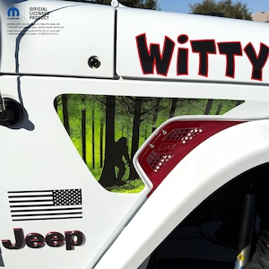 May include: White Jeep with the word "WITTY" in red letters. The Jeep features a forest scene with a Bigfoot silhouette. An American flag sticker and the word "Jeep" are also visible.