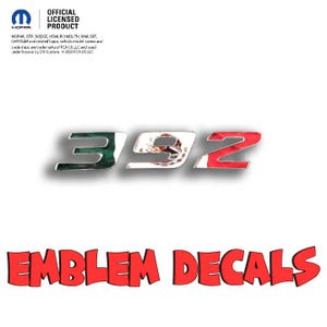 May include: Chrome-finished 392 emblem decals with green, white, and red accents, incorporating the Mexican flag design. The red text "EMBLEM DECALS" is displayed in a stylized font. The image also includes the Mopar logo and the text "OFFICIAL LICENSED PRODUCT."