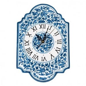May include: A white ceramic clock with blue floral designs and Roman numeral markings. The clock face has a smaller blue floral design in the center.