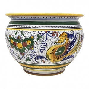 Op de afbeelding: Een grote, witte keramische plantenbak met een gele rand en een groene band. De plantenbak is versierd met een kleurrijk bloemenpatroon en een mythische vogel met een geel, groen en blauw ontwerp.