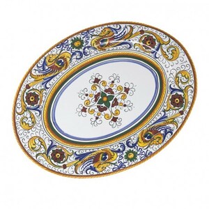 May include: Oval ceramic serving platter with a white background and a blue, yellow, and red floral design. The design features intricate swirls and scrolls.