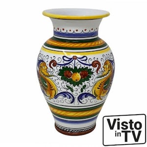 May include: A white ceramic vase with a yellow, green, blue and red floral pattern. The vase has a wide mouth and a narrow base. It is decorated with a traditional Italian design.