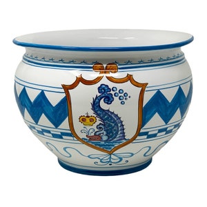 May include: A white ceramic planter with a blue and white chevron pattern and a blue and yellow crest featuring a seahorse. The crest is surrounded by a gold frame.