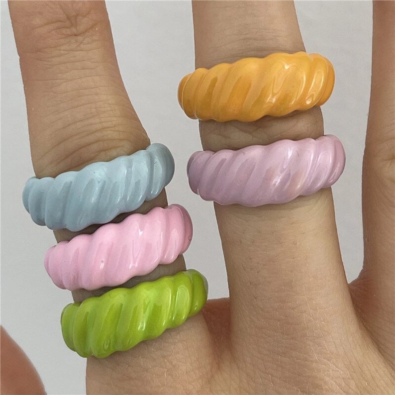 Hand wearing 5 Spiral Polymer Clay Rings in multi colours