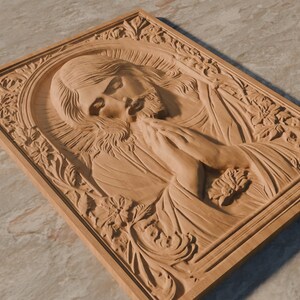 May include: A wooden carving of Jesus with his hands clasped in prayer. The carving is framed with a detailed floral design.