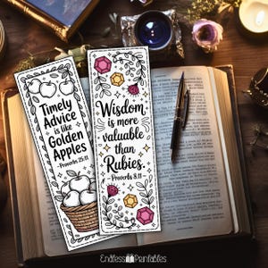 Op de afbeelding: Twee witte bladwijzers met zwarte tekst en illustraties liggen op een open boek. E&eacute;n bladwijzer leest "Timely Advice is like Golden Apples" met appelillustraties. De andere zegt "Wisdom is more valuable than Rubies" met edelsteenillustraties.