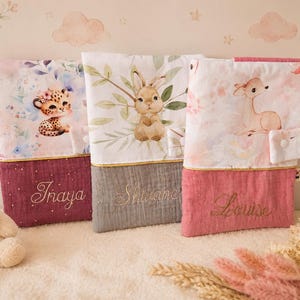 Pu&ograve; includere: Tre pochette rettangolari in tessuto con illustrazioni di animali: un leopardo, un coniglio e un cerbiatto. Ogni pochette presenta una sezione inferiore a tinta unita con i nomi ricamati Inaya, Shwane e Louise e una chiusura a bottone.