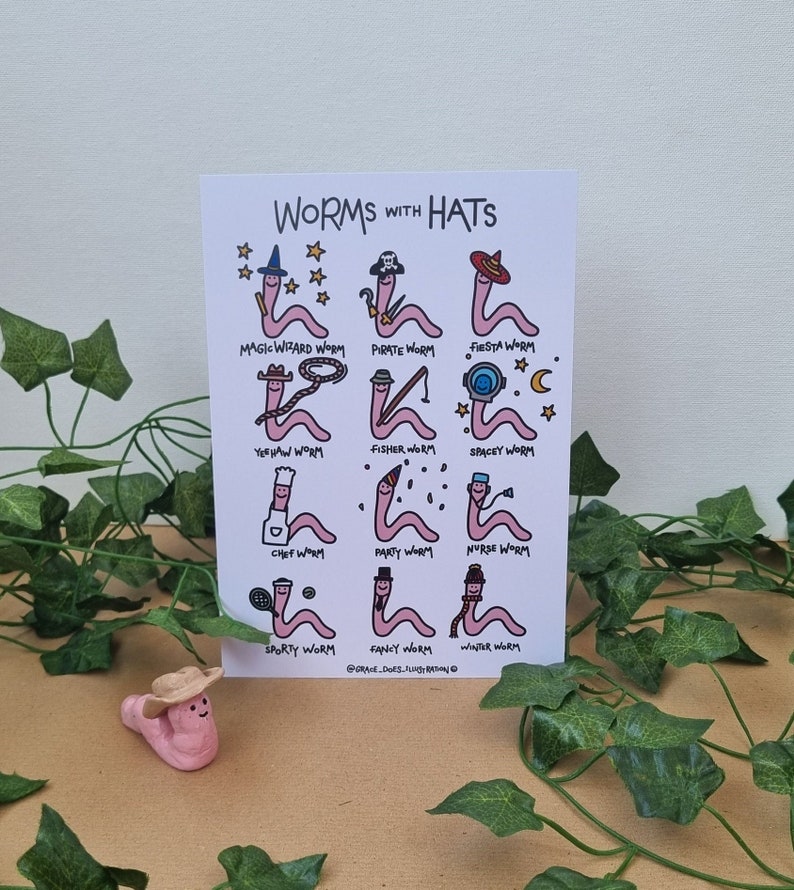 The art prints has nine illustrated worms on it, each one with a different hat on, including: wizard, pirate, sombero, cowboy, fisherman, astronaut, chef, party hat, nurse, tennis headband, top hat and winter hat and scarf.