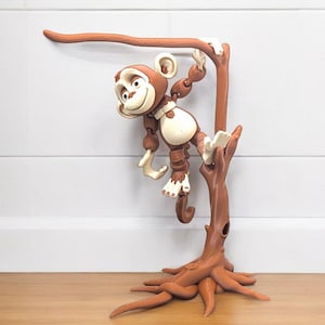 May include: A brown monkey figurine with a white belly is hanging from a brown tree branch. The monkey has a friendly expression and is holding onto the branch with its hands and feet. The tree branch is attached to a brown tree trunk with roots.