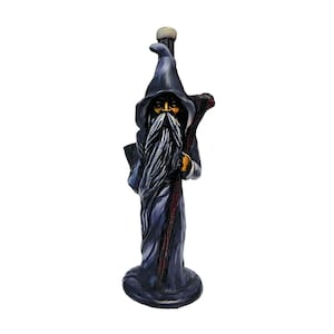 May include: A detailed figurine of a wizard in a long, dark blue robe and pointed hat. The wizard has a long, white beard and is holding a staff. The figurine is standing on a round base and has a detailed, hand-painted appearance.