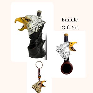 May include: A bundle gift set featuring an eagle head design. The set includes a pipe, a keychain, and a decorative piece. The eagle heads have yellow beaks, white and gray feathers, and are set against a black background.