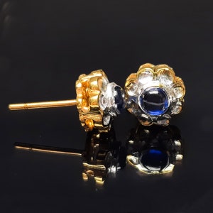 Puede incluir: Un par de pendientes de oro y plata con una piedra preciosa azul en el centro de cada pendiente.