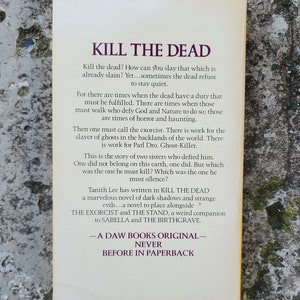May include: A paperback book cover with the title "KILL THE DEAD" in large purple text. The back cover features descriptive text about the novel, including the author, Tanith Lee, and a summary of the plot.