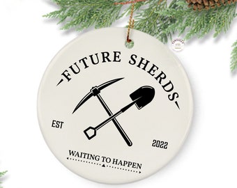 May include: White ceramic Christmas ornament with black text and graphics. The text reads "Future Shards - Est 2022 - Waiting to Happen". A pickaxe and shovel are crossed in the center of the ornament.