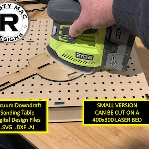 May include: A close-up of a wooden sanding table being sanded with a green power sander. The table is designed for vacuum downdraft and can be cut on a 400x300 laser bed. The text "Vacuum Downdraft Sanding Table Digital Design Files .SVG .DXF .AI" is visible on the table.