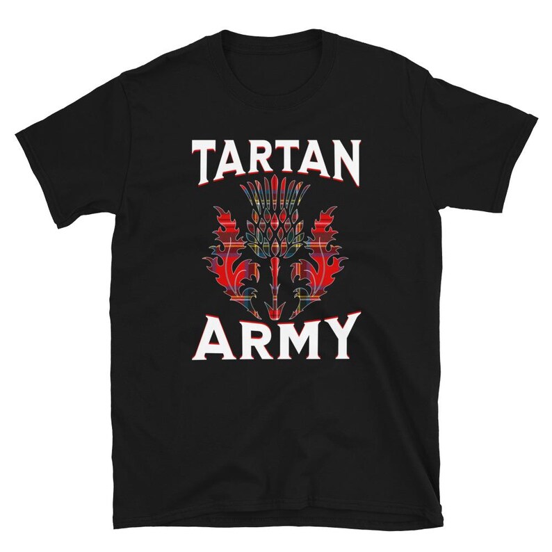 May include: Black t-shirt featuring the text "TARTAN ARMY" in white block letters above and below a colorful thistle emblem. The thistle design incorporates red, green, and yellow tartan patterns.