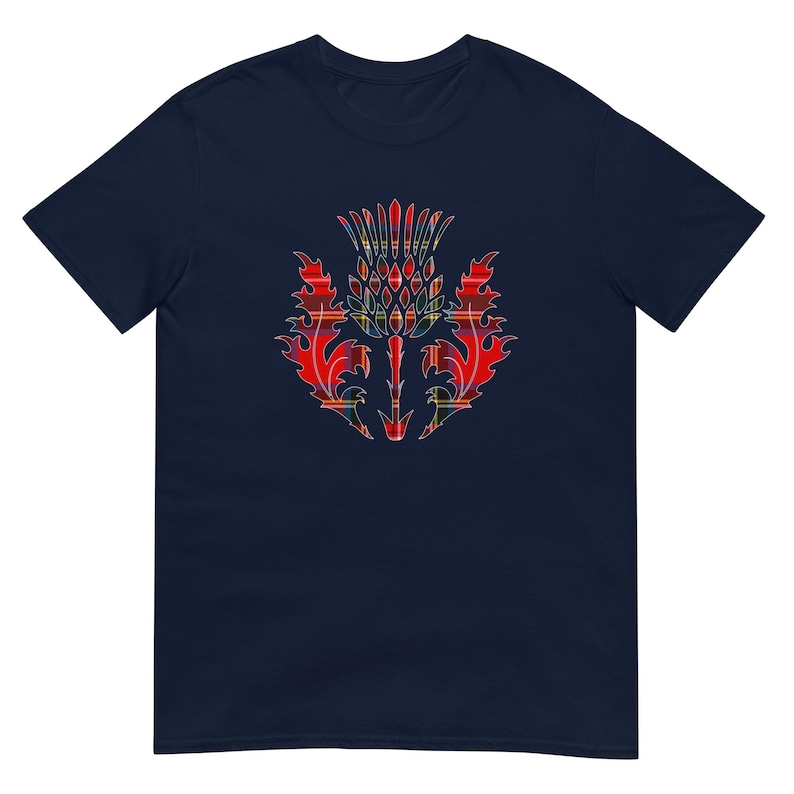 May include: A navy blue short-sleeve t-shirt featuring a central graphic of a thistle plant. The thistle design is filled with a red, yellow, and green plaid tartan pattern, showcasing sharp, pointed leaves and a textured, spiky flower head.