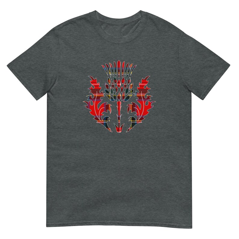 May include: A dark heather gray short-sleeve t-shirt featuring a central graphic of a thistle plant. The thistle design is filled with a red, yellow, and blue plaid tartan pattern, showcasing sharp, jagged leaves and a spiky, rounded flower head.