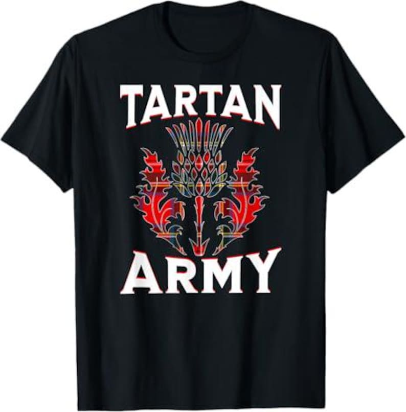 May include: Black t-shirt featuring the words "TARTAN ARMY" in white block letters above and below a colorful thistle design. The thistle is red, yellow, and blue.