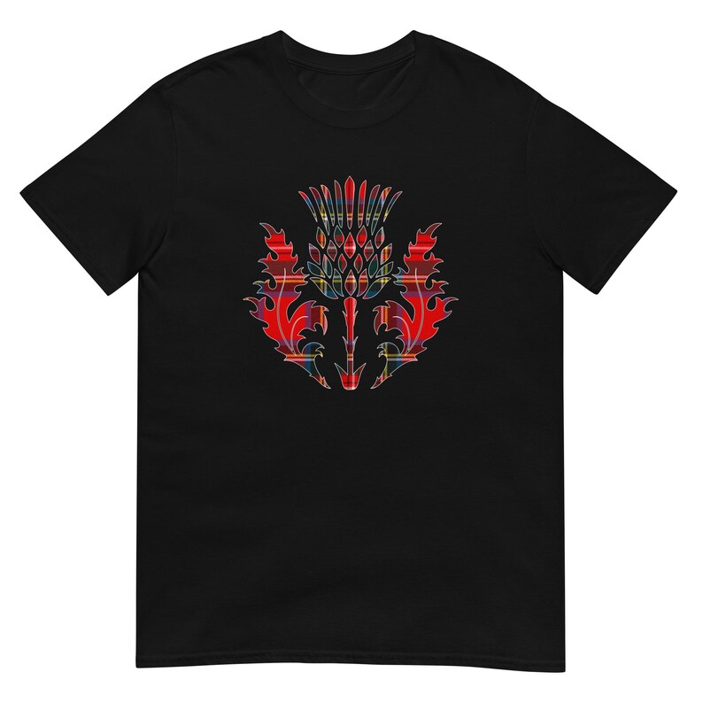 May include: A black short-sleeve t-shirt featuring a central graphic of a thistle plant. The thistle design is filled with a red, blue, and yellow plaid tartan pattern, showcasing sharp, jagged leaf edges and a detailed, segmented flower head.