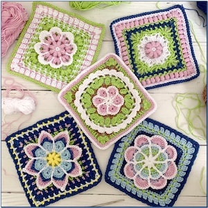 May include: Five crocheted squares with floral designs in shades of pink, green, blue, and white. The squares are arranged on a white wooden surface.