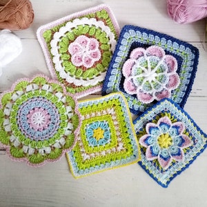 May include: Five crocheted squares with floral designs in shades of pink, blue, green, and yellow. The squares are made with different stitch patterns and have a variety of border designs.