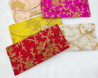 May include: Assortment of colorful fabric envelopes with gold embroidery. The envelopes feature floral patterns and are perfect for gifting or special occasions.