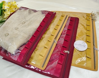Puede incluir: Tres bolsas de almacenamiento con cremallera y ventanas de plástico transparente. Las bolsas están forradas con tela roja, dorada y burdeos. Las bolsas están acolchadas y tienen un volante decorativo a lo largo del borde. Las bolsas están etiquetadas con "Wardrobe" en un círculo blanco.