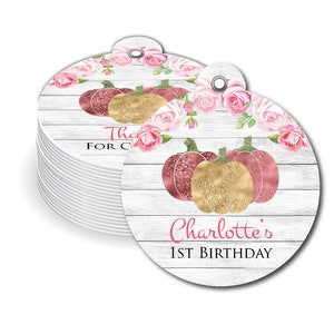 May include: Round, white, wood-grain patterned gift tags with pink roses and gold glitter pumpkins. The text on the tag reads "Charlotte's 1st Birthday".
