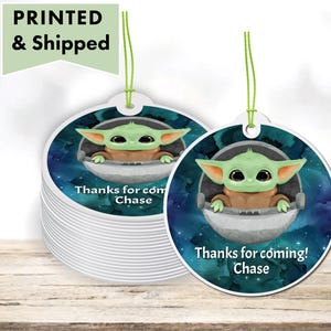 May include: Round favor tags with a green alien character in a spaceship against a blue and purple galaxy background. The text on the tag reads "Thanks for coming! Chase".