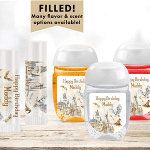 May include: Four hand sanitizer bottles with labels featuring a Hogwarts castle design and the text "Happy Birthday Maddy". The bottles are filled with clear liquid and have white caps.