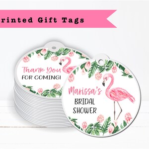 May include: Round white gift tags with pink flamingos and green tropical leaves. The text on the tags reads "Thank You For Coming!" and "Marissa's Bridal Shower".