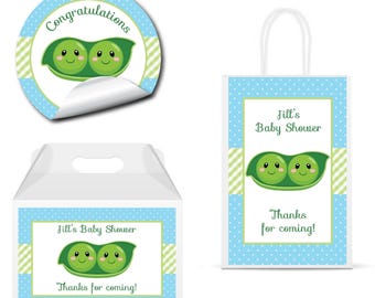 May include: A round sticker with the text Congratulations, a white gift box, and a white gift bag, all featuring a green pea pod graphic with two smiling faces, light blue polka dot patterns, and green striped accents for a baby shower.