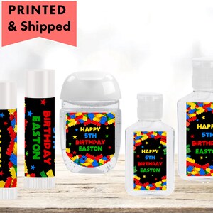 May include: Set of five personalized hand sanitizer labels featuring a colorful Lego block design. The labels say "Happy 5th Birthday Easton".