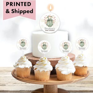 May include: A set of six cupcake toppers featuring a green baby onesie with floral accents. The toppers are printed with the text "Christina's Baby Shower".