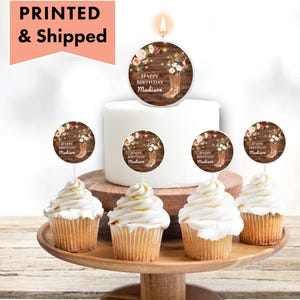 May include: Set of six cupcake toppers with a rustic wood background, floral accents, and a pair of cowboy boots. The toppers say "Happy Birthday Madison".