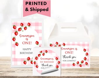 May include: White party favor boxes and stickers with a pink gingham pattern and red strawberries. Text includes "Emmerson is ONE!" and "Happy Birthday". The image also says "Thank you for coming!"