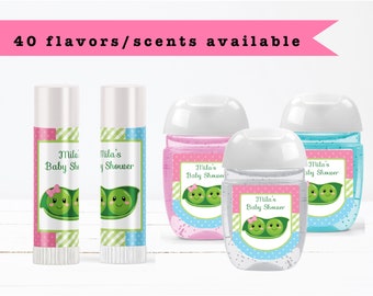 May include: Set of four baby shower favors featuring hand sanitizer bottles and lip balm tubes. The labels are pink and blue with a green peapod design and the text "Mila's Baby Shower".