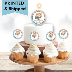 May include: A white cake with a round topper that says "Congratulations Christina" and a candle on top. There are six cupcakes with round toppers that say "Congratulations Christina" on a wooden cake stand.