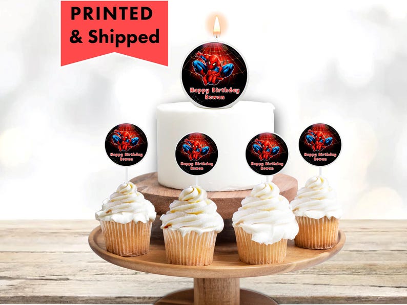 A birthday cake with a Spiderman-themed candle and cupcakes decorated with Spiderman images.