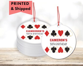 May include: Round white gift tags with red and black playing card symbols and gold accents. The text on the tag reads "Cameron's 50th Birthday".