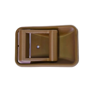 May include: A brown plastic door handle with a rectangular shape and a latch mechanism. The handle has a smooth, slightly textured surface.