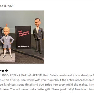 May include: Three custom-made figurines of people, two men and one boy, standing on a table with a black book titled "The Pre-Aging Playbook".