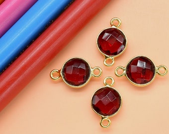 May include: Four gold-toned connector charms with red faceted glass stones. Each charm has two loops for attaching to jewelry.